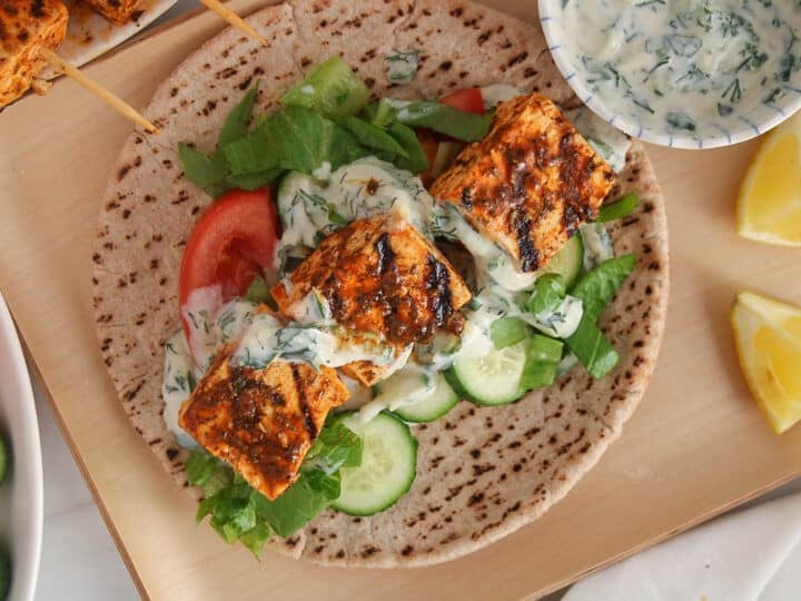 Vegan tofu souvlaki on pita bread with lettuce and tzatziki sauce.