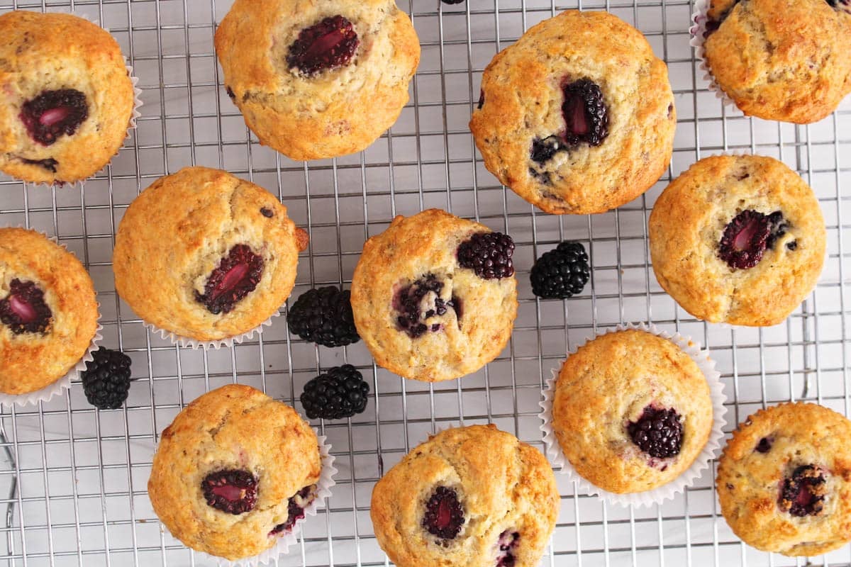Blackberry banana muffins on a cooling rack.