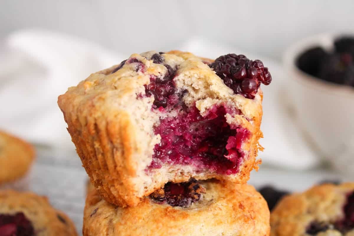A blackberry banana muffin with a bite taken off.