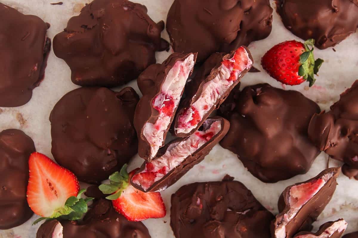 Sliced strawberry yogurt clusters over parchment paper.
