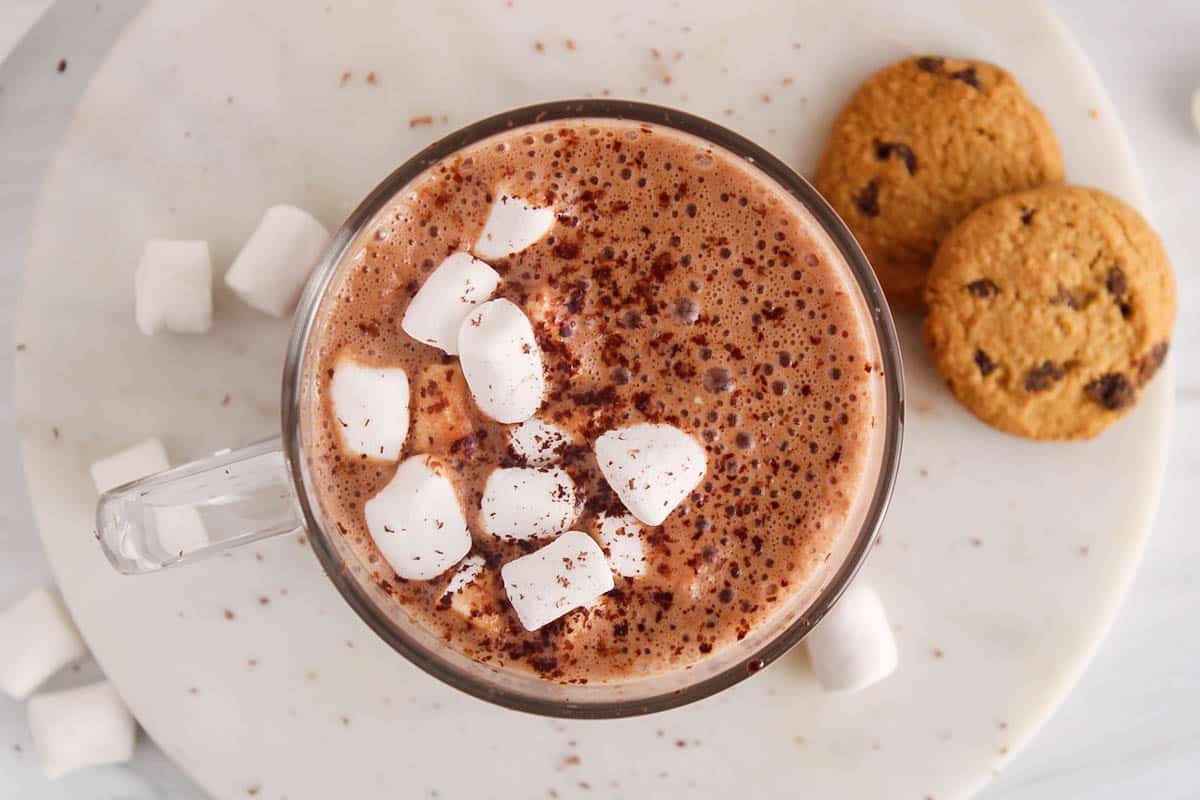 Hot chocolate made with oat milk and protein powder topped with marshmallow and shaved chocolate.