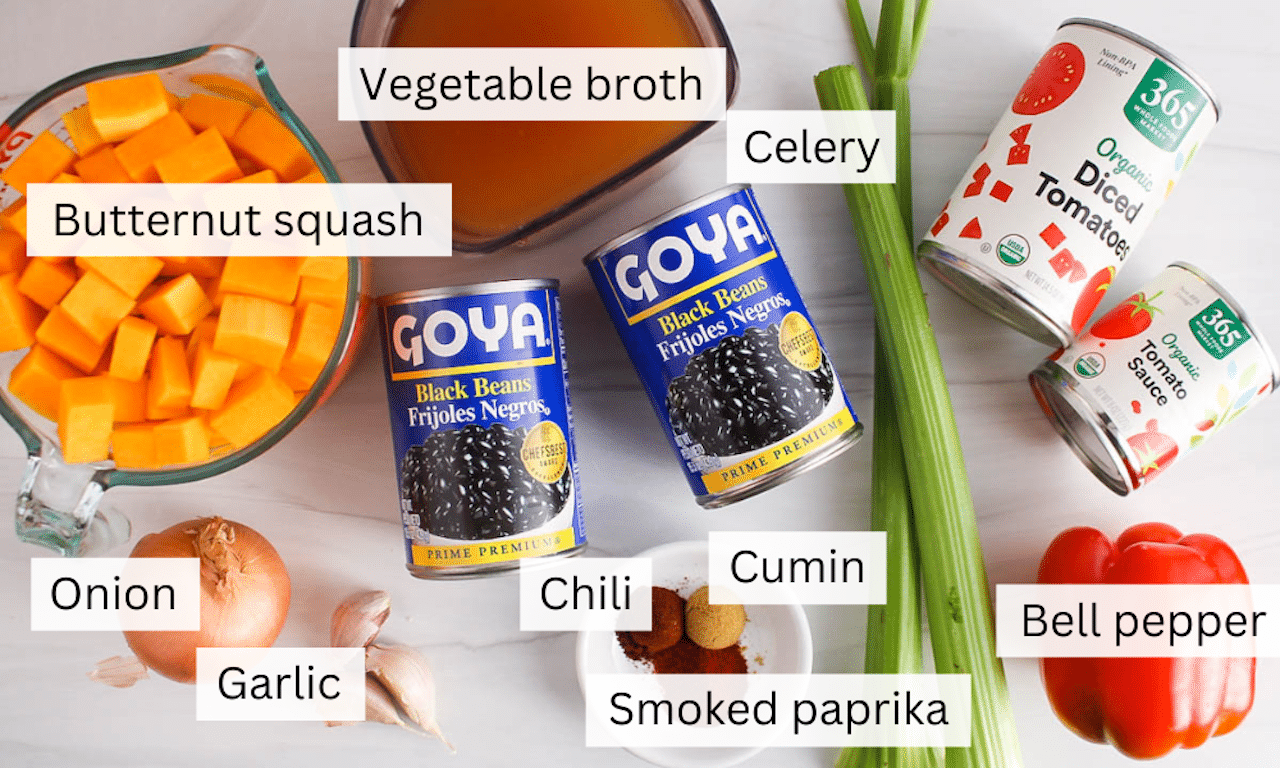 Ingredients needed to make a black bean butternut squash soup on a white table.