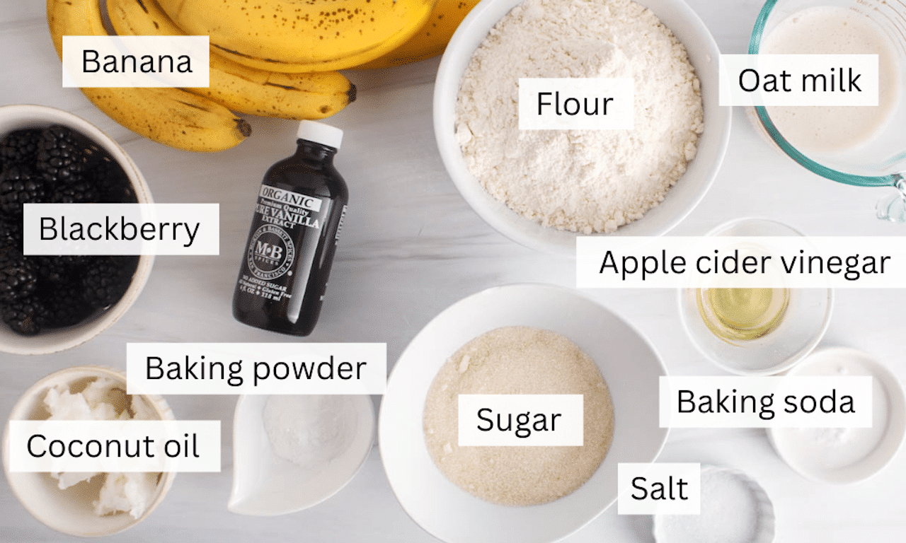 Ingredients to make blackberry banana muffins on a white table.