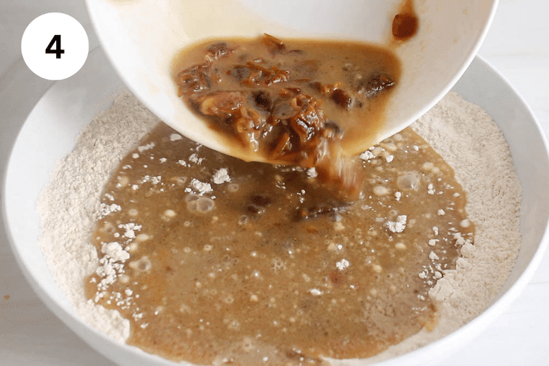 A bowl of date in a liquid pouring over a large bowl with flour and seasoning.