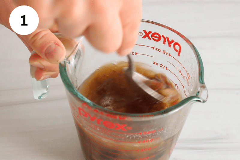 A glass bowl with date and a spoon stirring.