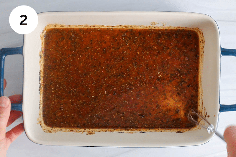 A large container with a whisked marinade.