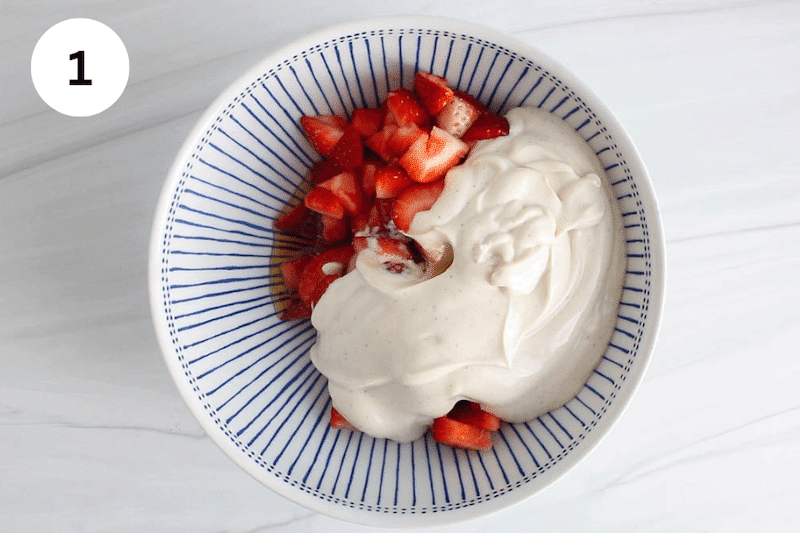 A bowl with chopped strawberries, yogurt and maple syrup.