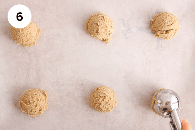 6 balls of cookie dough on a baking sheet.