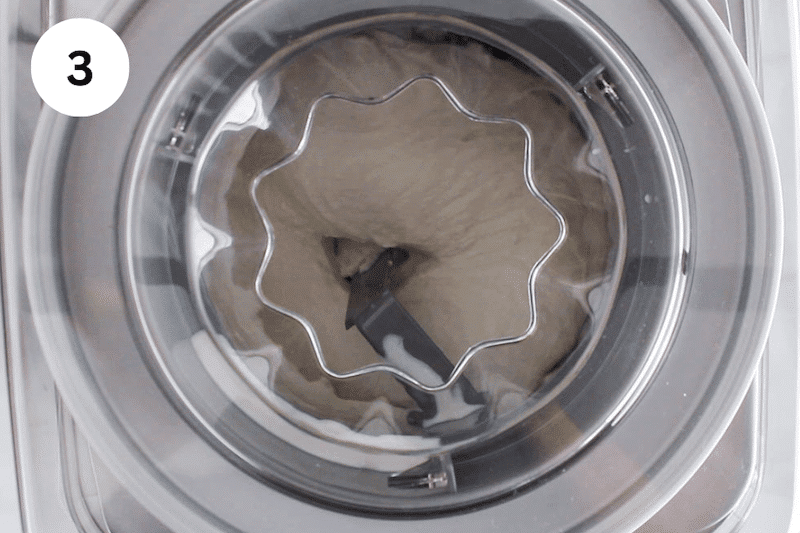 An ice cream machine churning a creamy mixture.