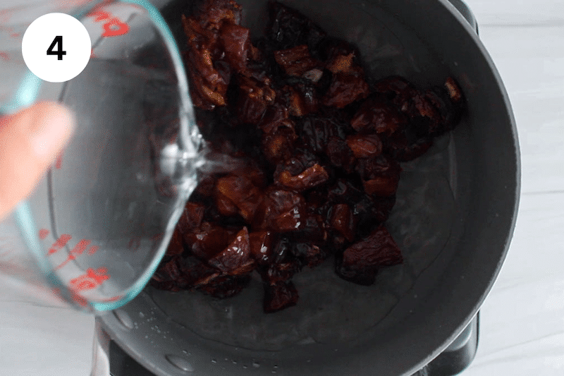 A small saucepan with date and a jar pouring water over.
