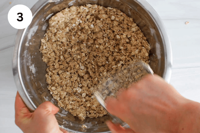 A pastry cutter mashing in a bowl with oats and vegan butter.