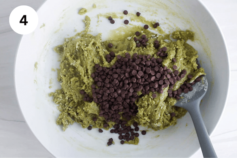A bowl with a green matcha cookie dough topped with chocolate chips.