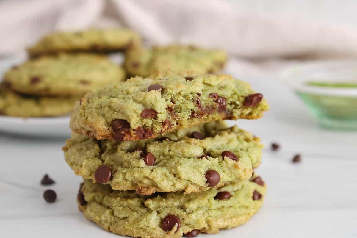 A few vegan chocolate chip matcha cookies piled over each other.