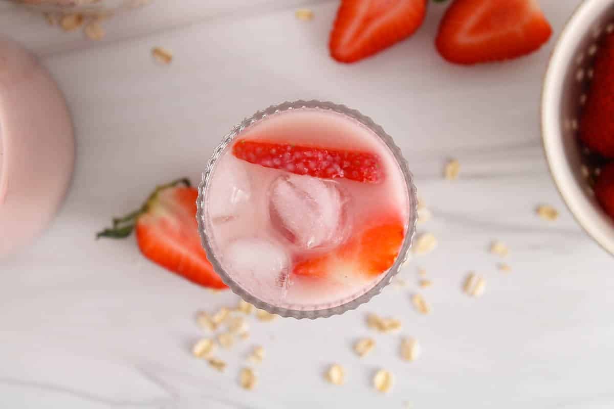Glass of oat milk made with fresh strawberries.