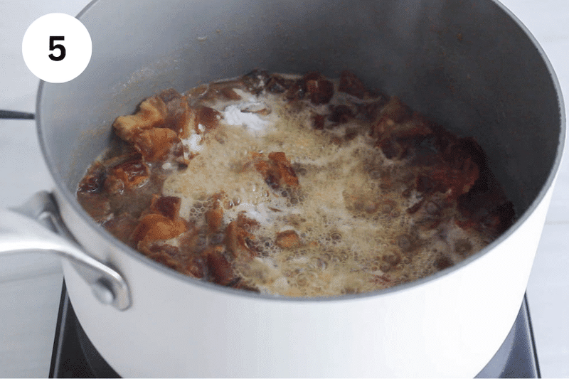 Small pot with a saucy date mix topped with baking soda.