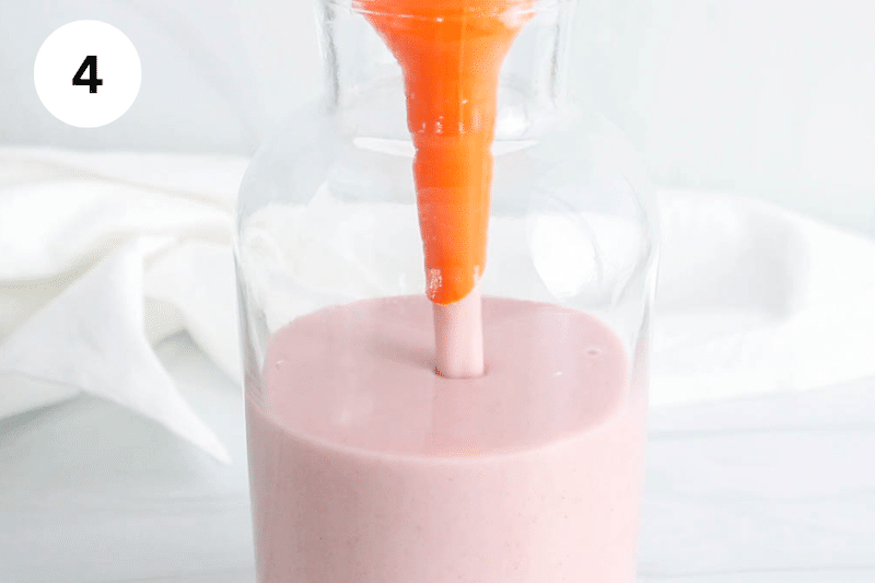 A pink milk pouring in a jar.