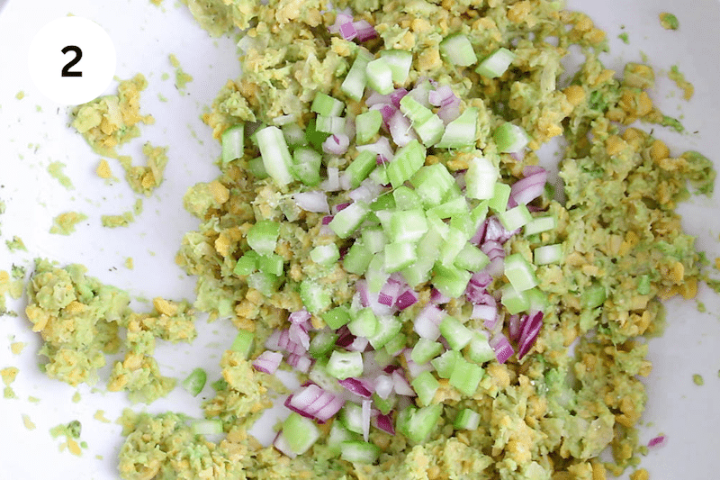 Mashed chickpeas and avocado topped with red onion and celery.