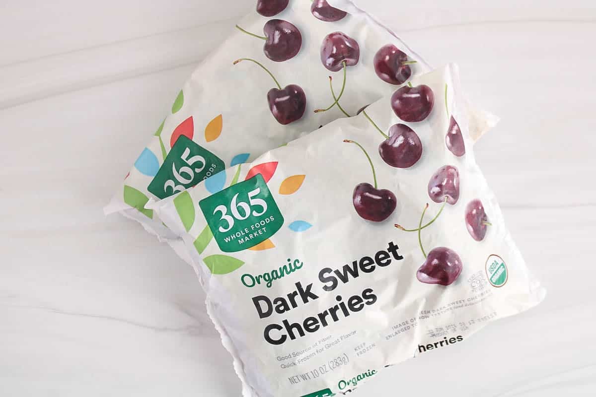 2 bags of frozen cherries on a white surface.
