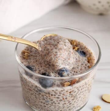 A spoon stirring in a jar of vegan chia and flaxseed pudding.