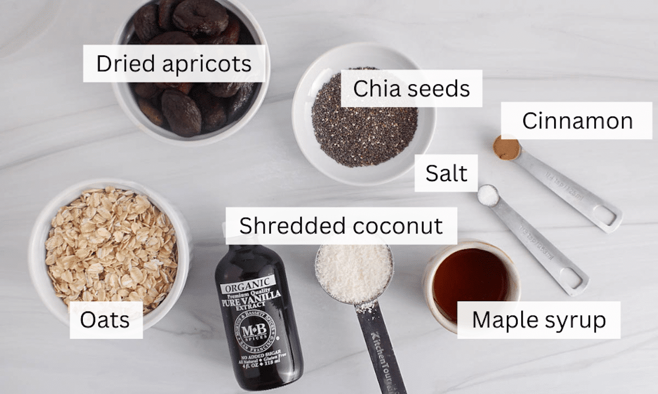 Ingredients to make healthy apricot bliss balls placed o a white table.