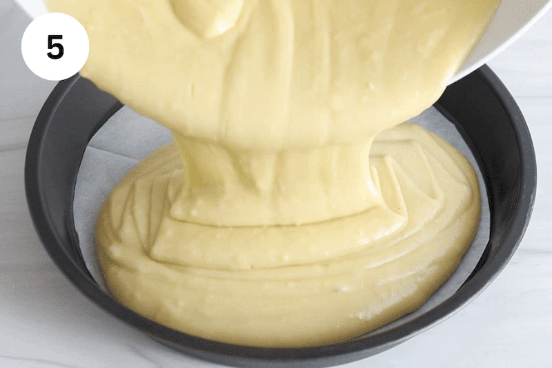 A bowl pouring a cake batter into a round cake mold.