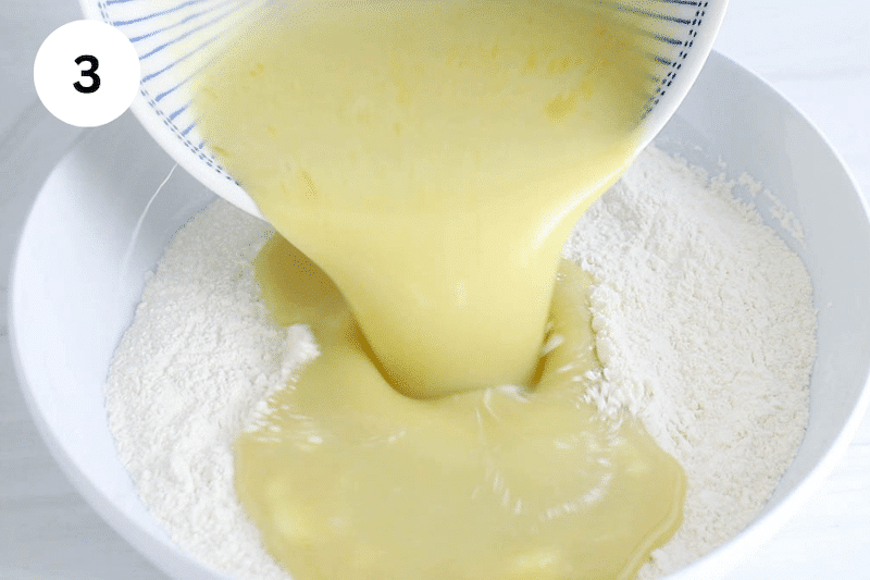 A wet mixture pour in a bowl with flour.