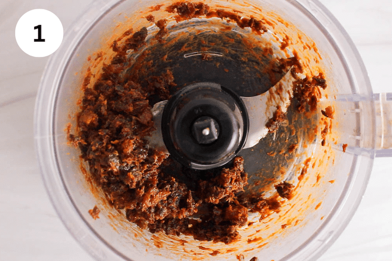 Food processor filled with processed dried apricot.