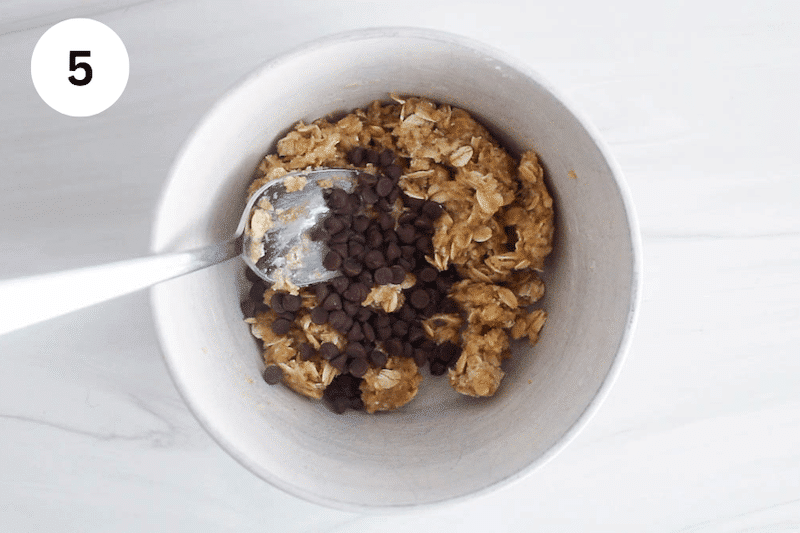 A bowl with cookie dough and chocolate chips over.