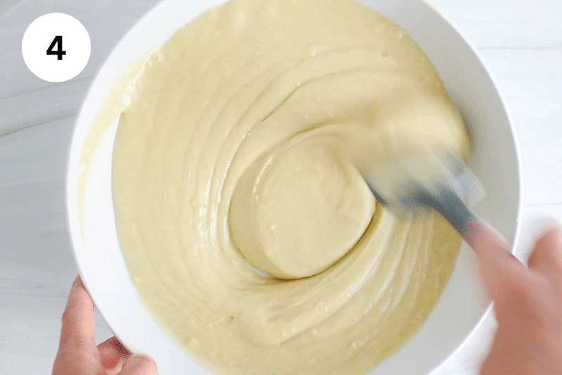 A large bowl with a spatula mixing a cake batter.