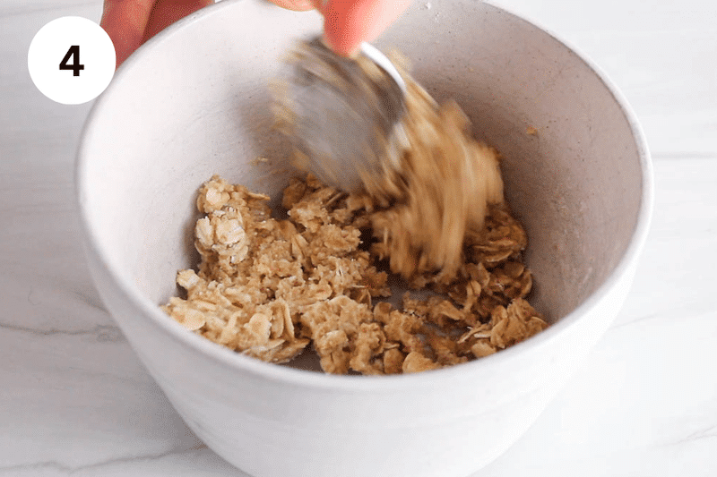 A spoon mixing cookie dough in a bowl.