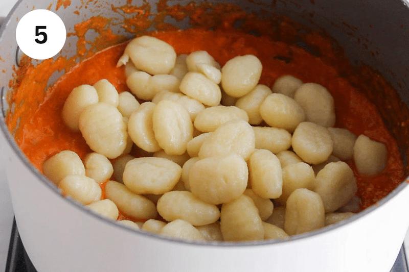Boiled gnocchi over tomato pesto sauce.