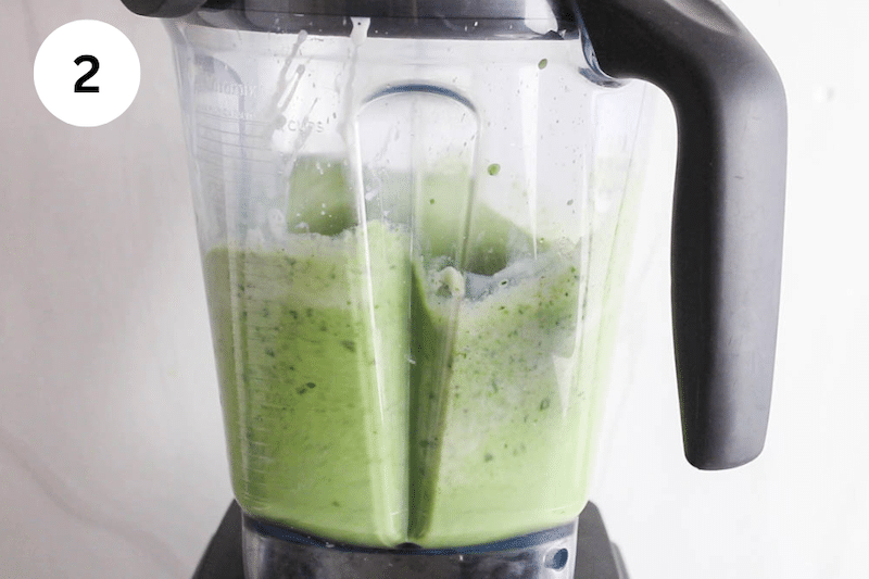 A blender filled with a creamy green smoothie mixture.