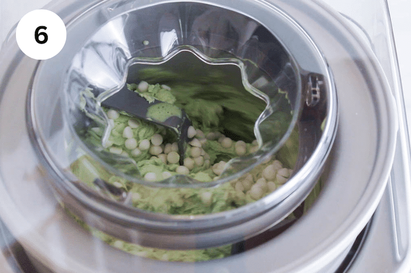 Matcha ice cream with white chocolate chips in an ice cream maker.