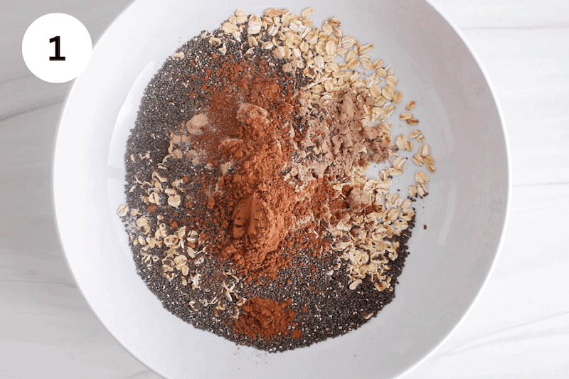 A large mixing bowl with oat, chia seeds and cacao powder.