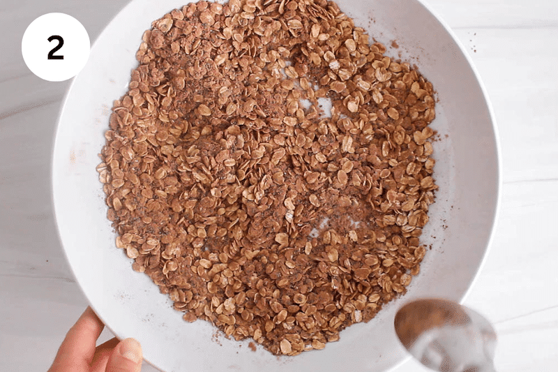 A mixing bowl with a spoon stirring the pats and other dry ingredients.