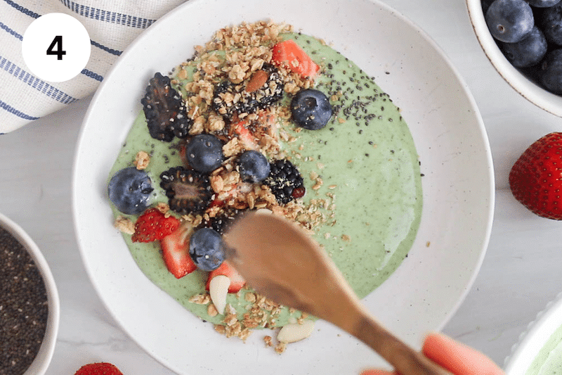 A small spoon sprinkling chia seeds over a bowl with yogurt.