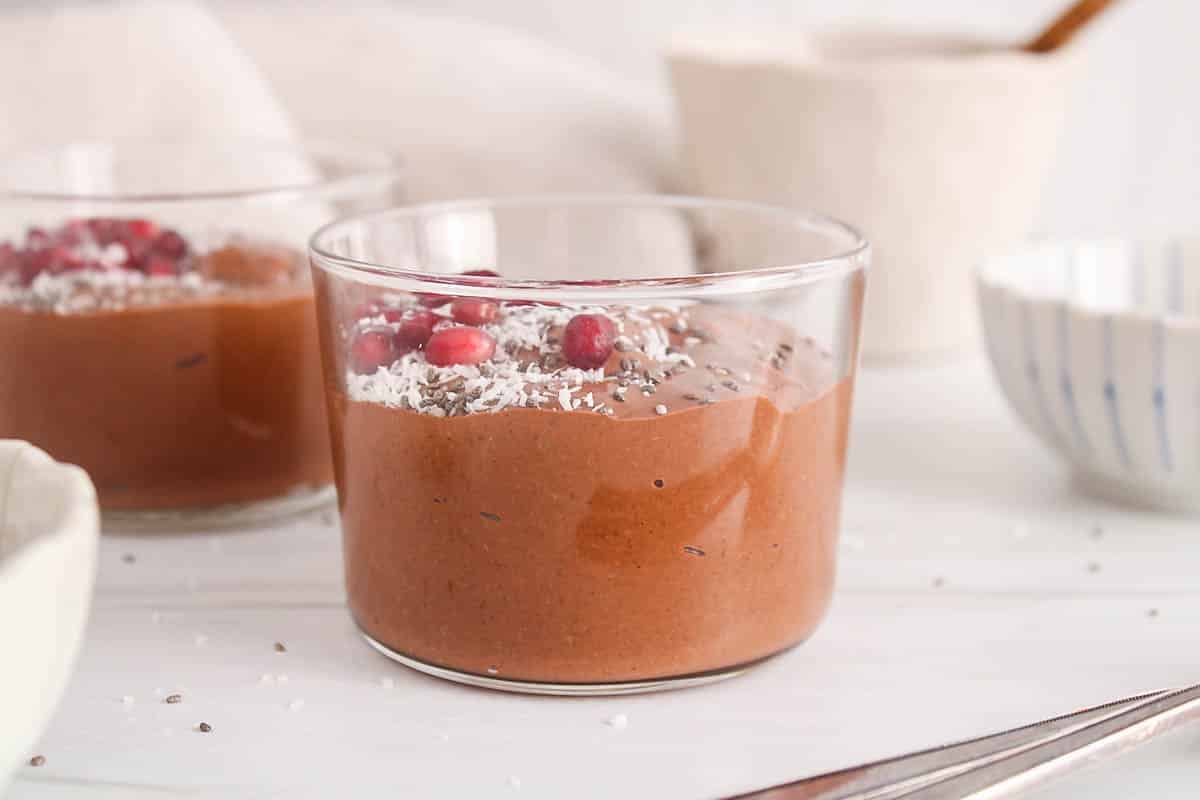 A see-through glass jar filled with blended high protein chia chocolate pudding.