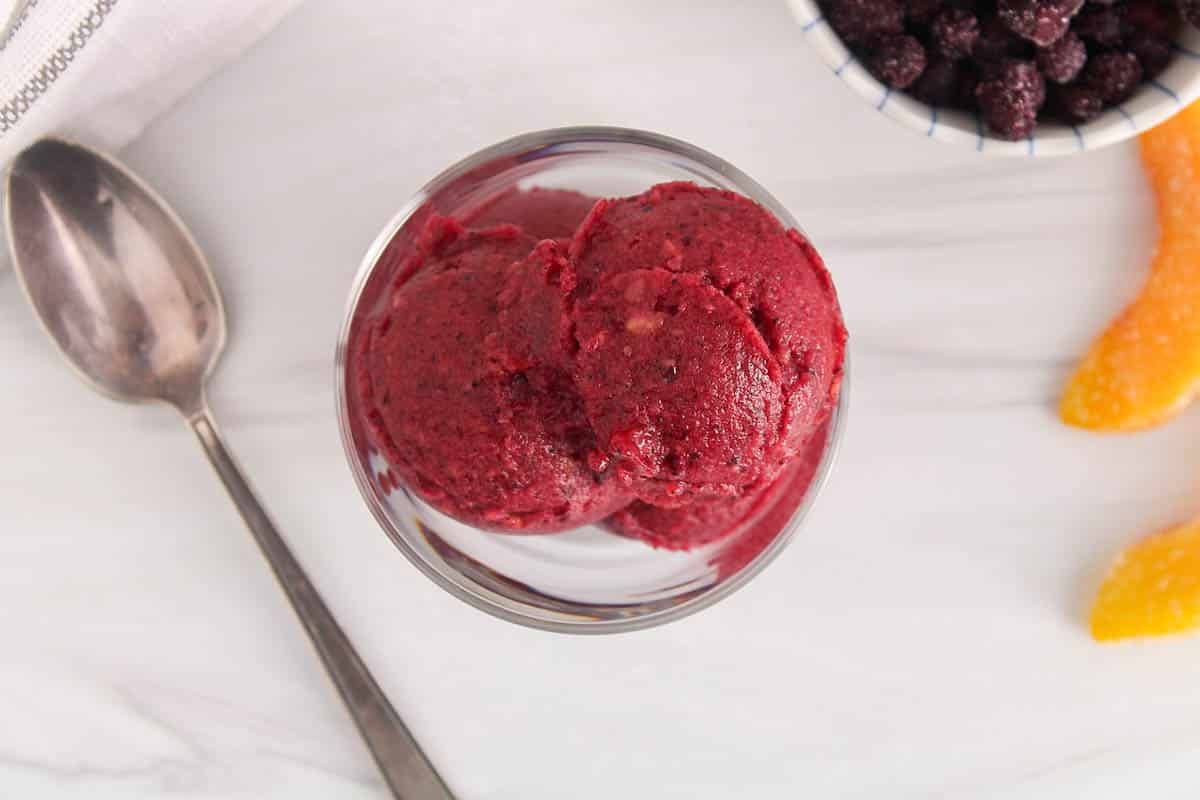 A see-through bowl filled with some blueberry peach sorbet.