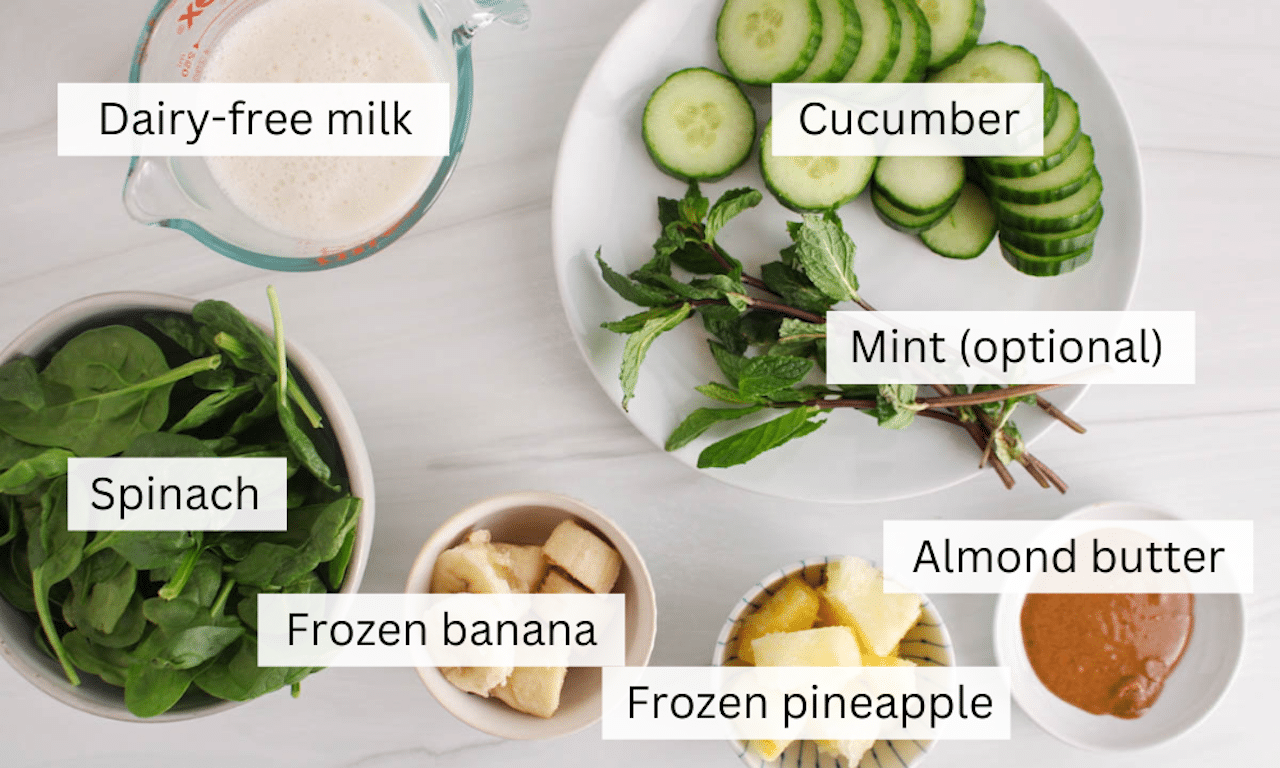 Ingredients needed to make a cucumber spinach smoothie placed on a table.