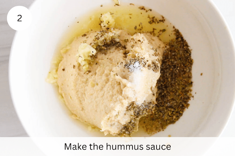 A small bowl with hummus, lemon juice and spices.