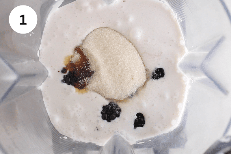 Milk and blackberries in a blender.