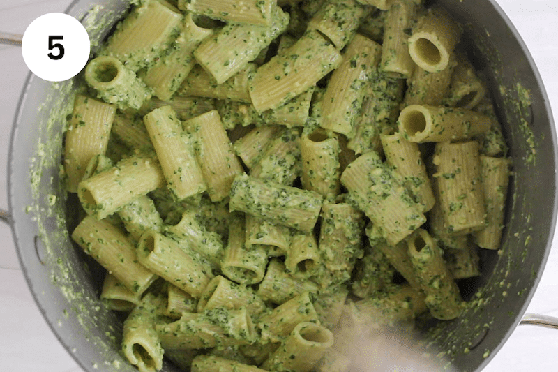 Large pot with creamy pesto rigatoni.
