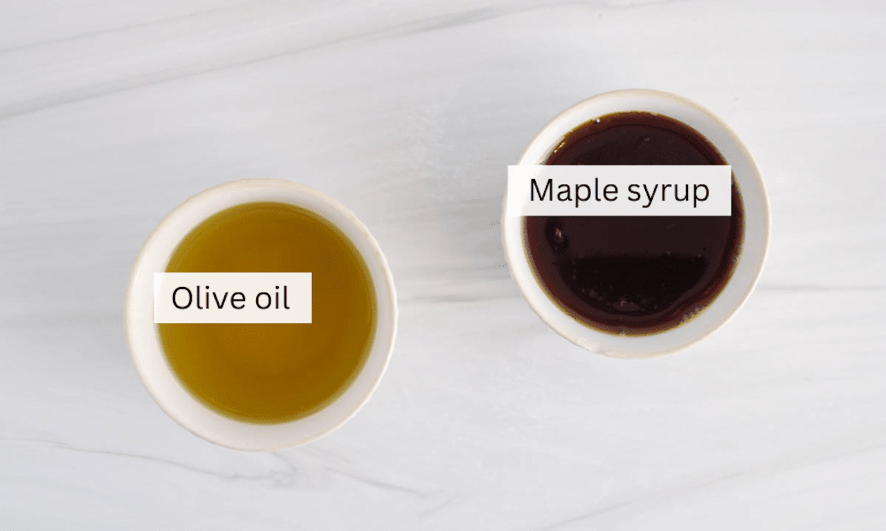 2 bowls containing olive oil and maple syrup placed on a table.