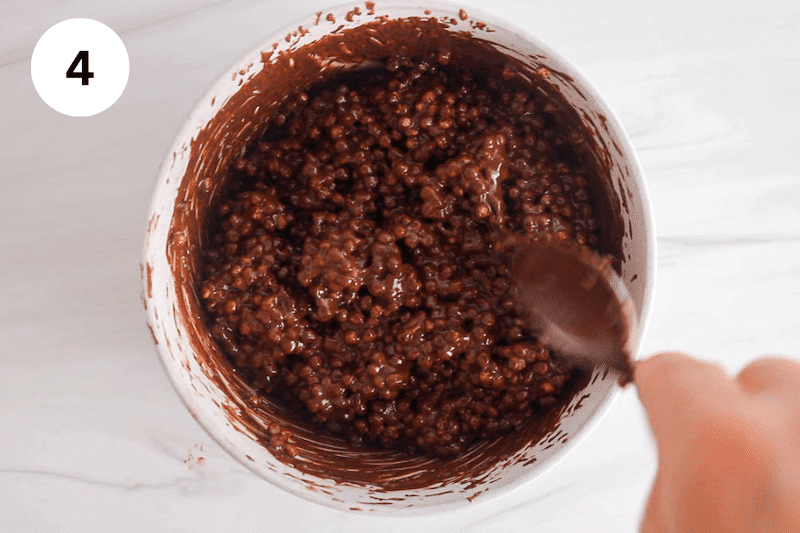 A bowl with chocolate sauce mixed with quinoa puffs.