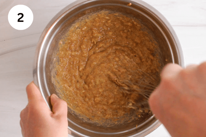 A bowl with a creamy banana mixture with a whisk stirring.