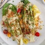 Wedges of grilled romaine hearts garnished with tahini cesar dressing, breadcrumbs and cherry tomatoes.