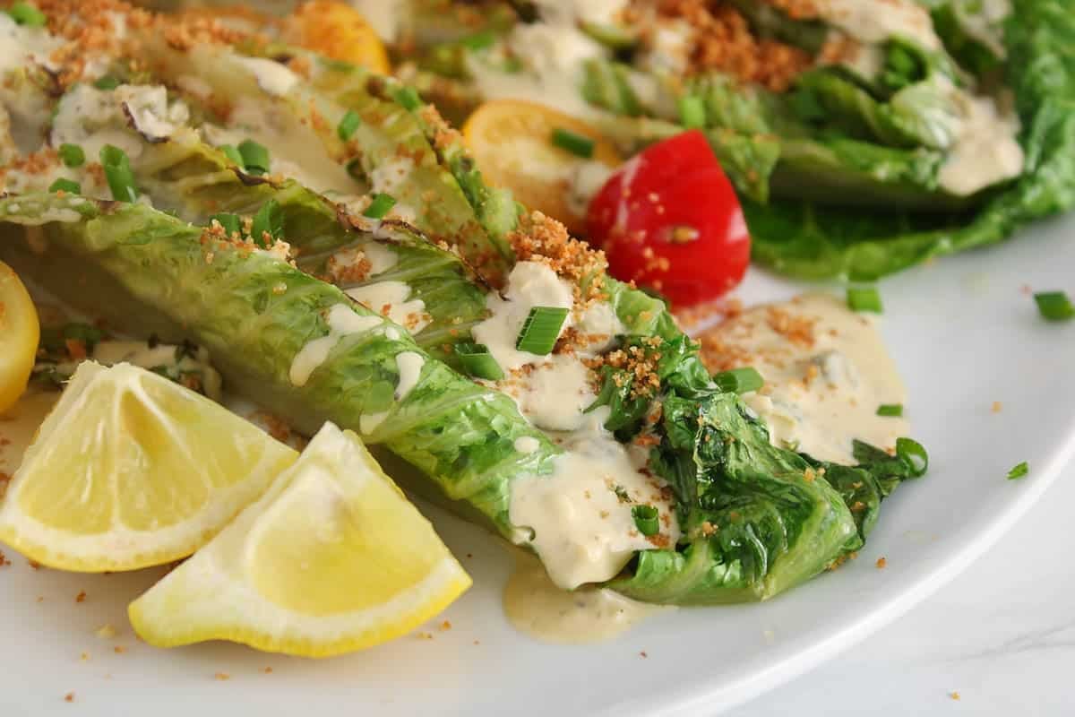Grilled romaine topped with tahini cesar sauce.