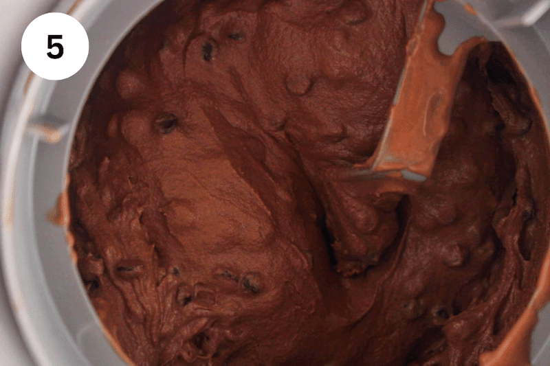 A churned chocolate ice cream filled with chocolate chips in an ice cream maker.