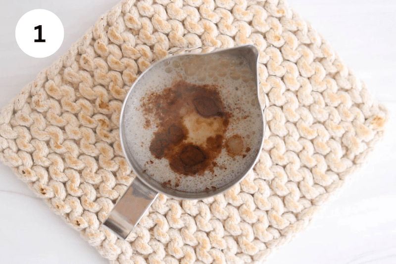 A metal dish with warm milk and spices.