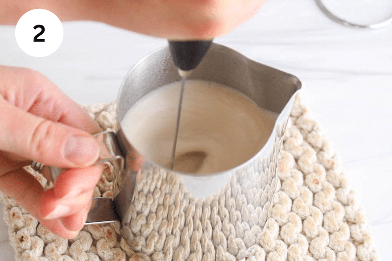A frother frothing milk and spices.